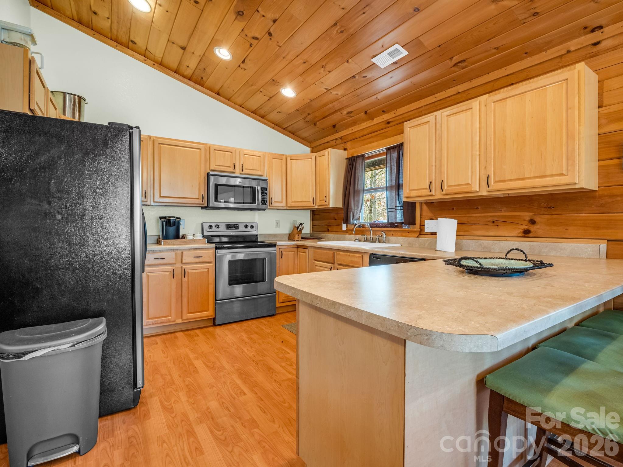 1050 Cross Ridge Drive Rutherfordton, NC 28139 - Photo 17 of 48 a kitchen with stainless steel appliances granite countertop a sink a stove and a refrigerator with wooden floors