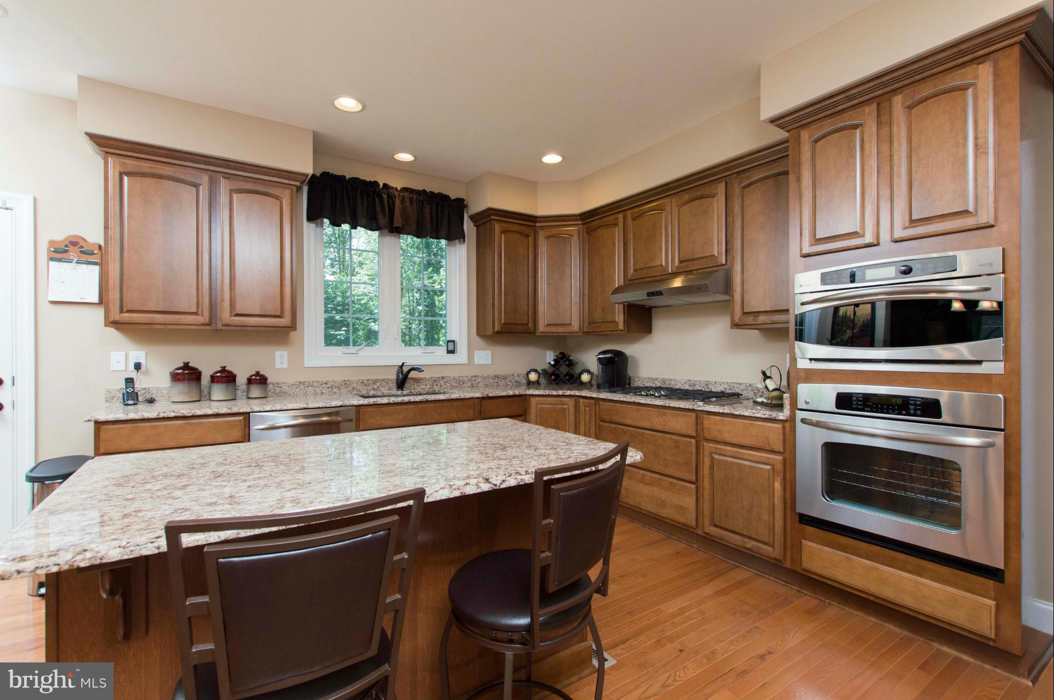 2320 Pleasantville Road Fallston, MD 21047 - Photo 12 of 30 a kitchen with granite countertop wooden cabinets a stove a sink and a window