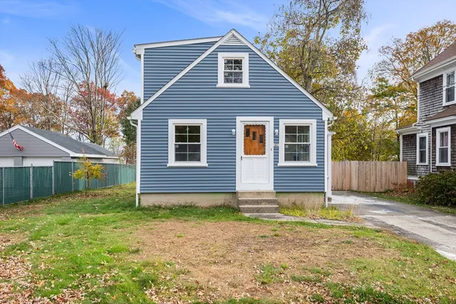 a view of a house with backyard and tree