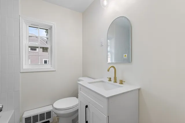 a bathroom with a toilet sink and mirror