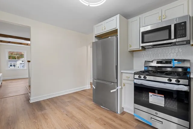 a kitchen with stainless steel appliances a stove a microwave and a hard wood floors