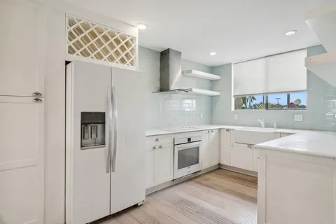 a kitchen with cabinets and wooden floor
