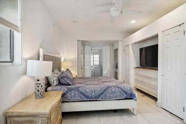 a bedroom with a large bed and a flat tv screen