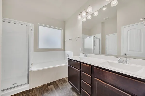 a bathroom with a tub a sink and a mirror