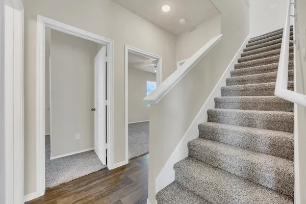 a view of staircase with white walls and wooden floor