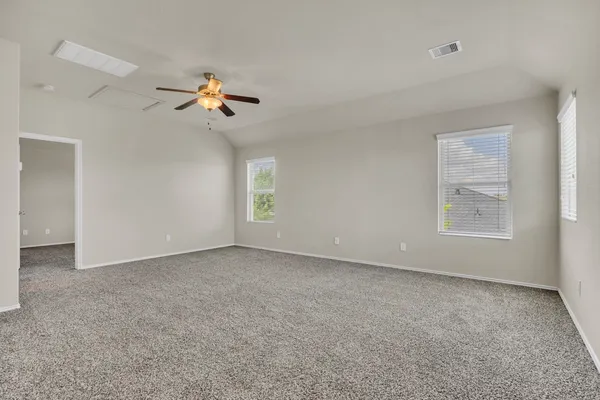 an empty room with windows and fan