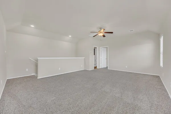 a view of an empty room with a ceiling fan