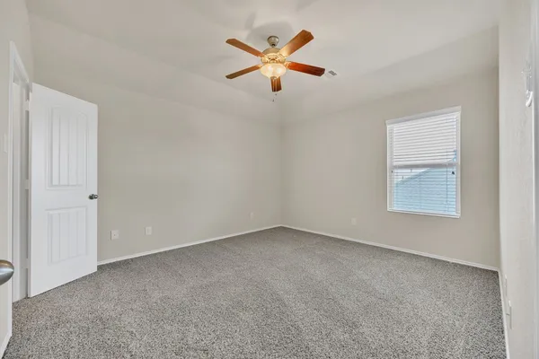 an empty room with closet and ceiling fan