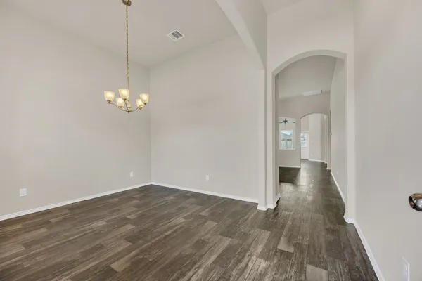 a view of a room with wooden floor and a chandelier