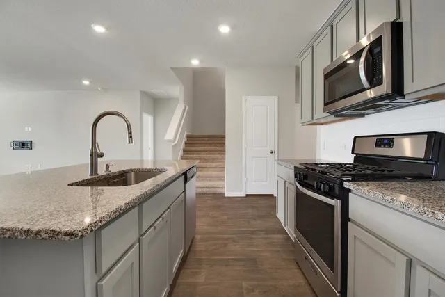 a kitchen with granite countertop stainless steel appliances and a sink
