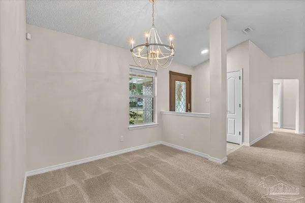 a view of a dining room with furniture and chandelier