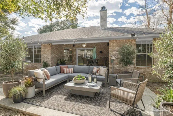 a view of a patio with couches table and chairs and potted plants
