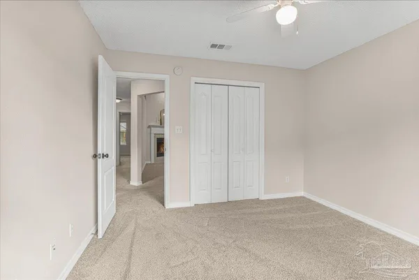 an empty room with closet and a chandelier fan