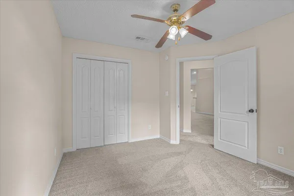 an empty room with a window and a fan