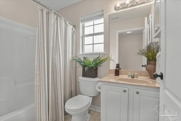 an empty room with a fan and a bathroom