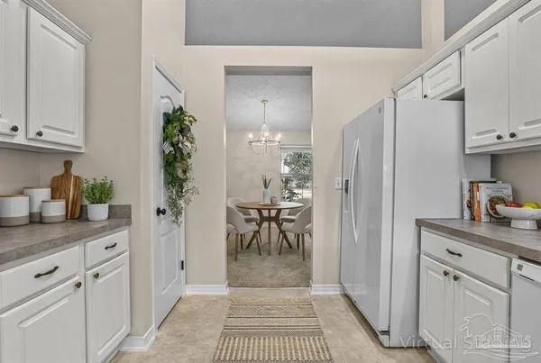 a kitchen with cabinets a sink dishwasher and white appliances