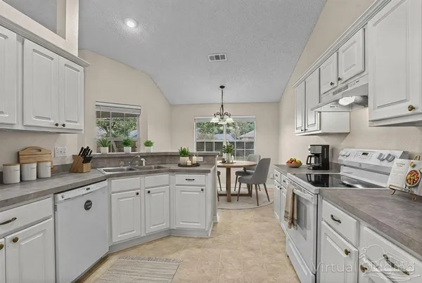 a kitchen with white cabinets and chairs
