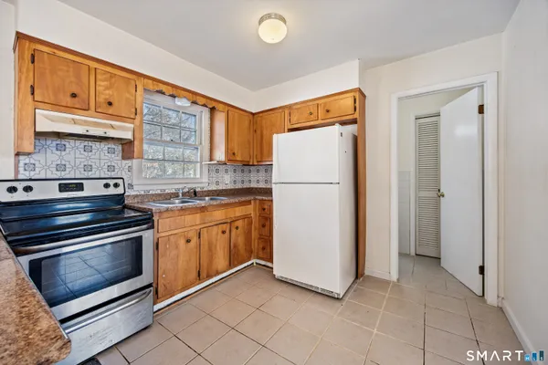 a kitchen with a refrigerator sink and cabinets