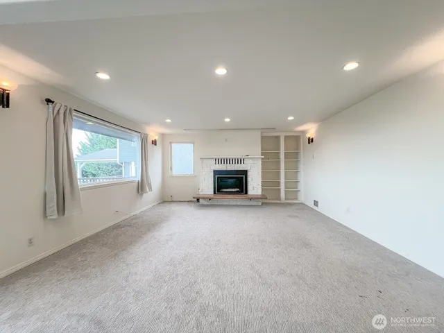 a view of a livingroom with an empty space and a fireplace