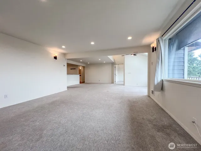 a view of a big room with a fireplace and windows