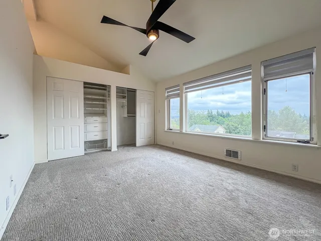 an empty room with windows and closet