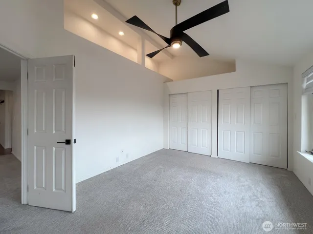 an empty room with fan ceiling fan and windows