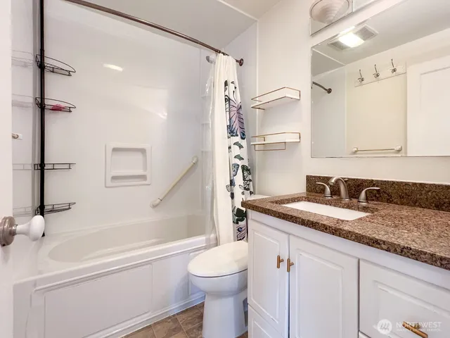 a bathroom with a granite countertop sink toilet and shower