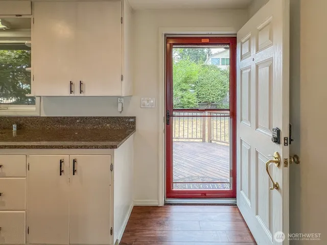 a view of a hallway with wooden floor and entryway