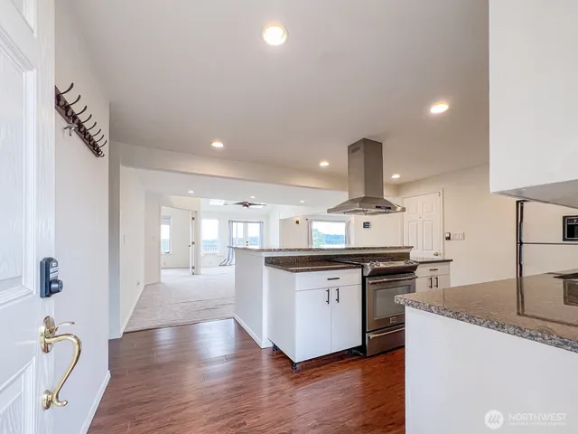 a kitchen with stainless steel appliances granite countertop a sink stove and wooden floor
