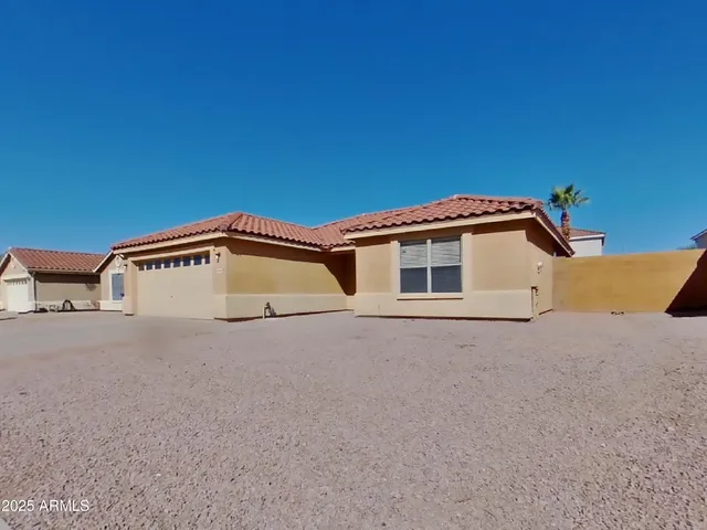 a white house with a large parking space