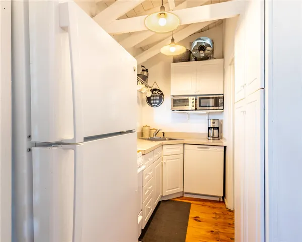 a kitchen with a refrigerator and white cabinets