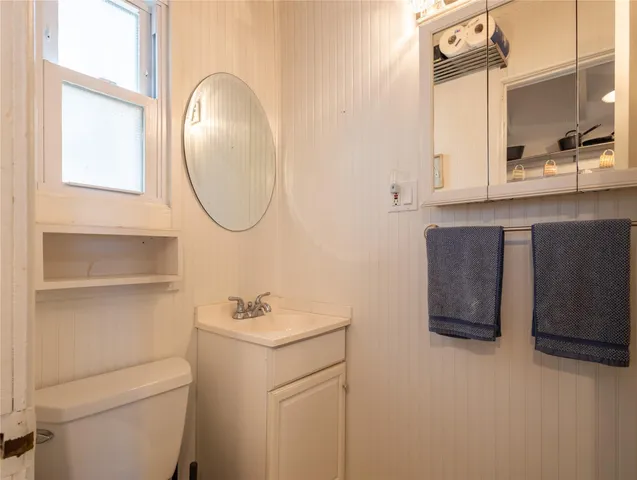 a bathroom with a toilet a sink and mirror