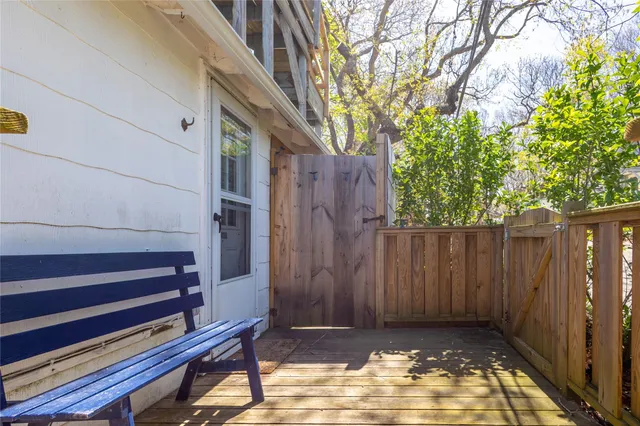 a view of backyard with wooden fence and large trees