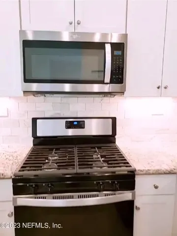 a stove top oven sitting inside of a kitchen