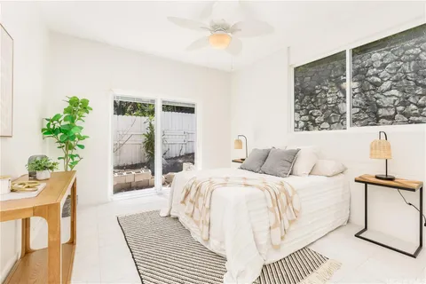 a bedroom with a large bed and a potted plant