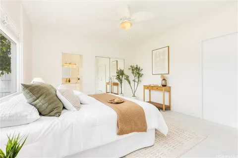 a bedroom with a bed and a painting on the wall