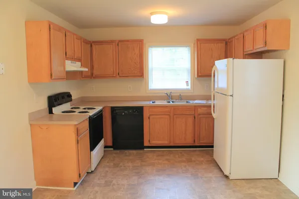 a kitchen with a refrigerator sink stove and cabinets