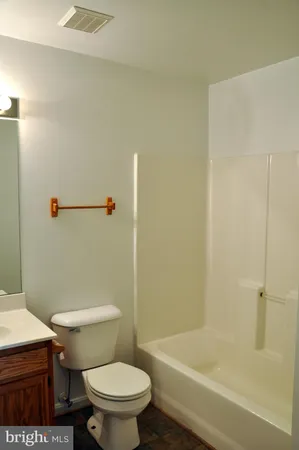 a white toilet sitting next to a bath tub