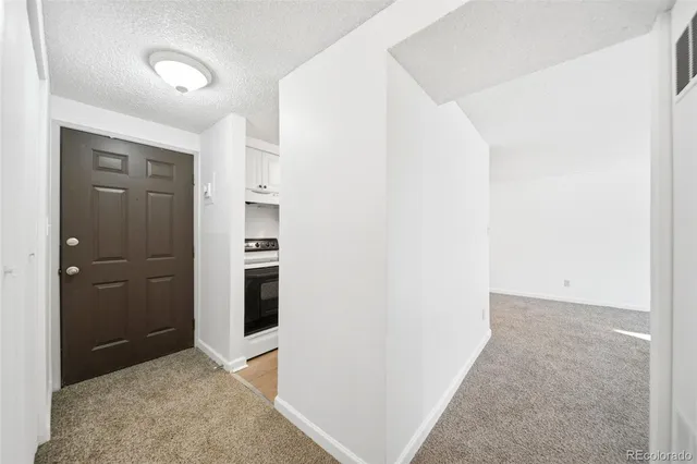 a kitchen with a sink dishwasher stove and white cabinets