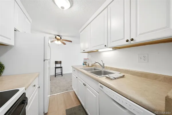 a view of a kitchen with a sink and a refrigerator