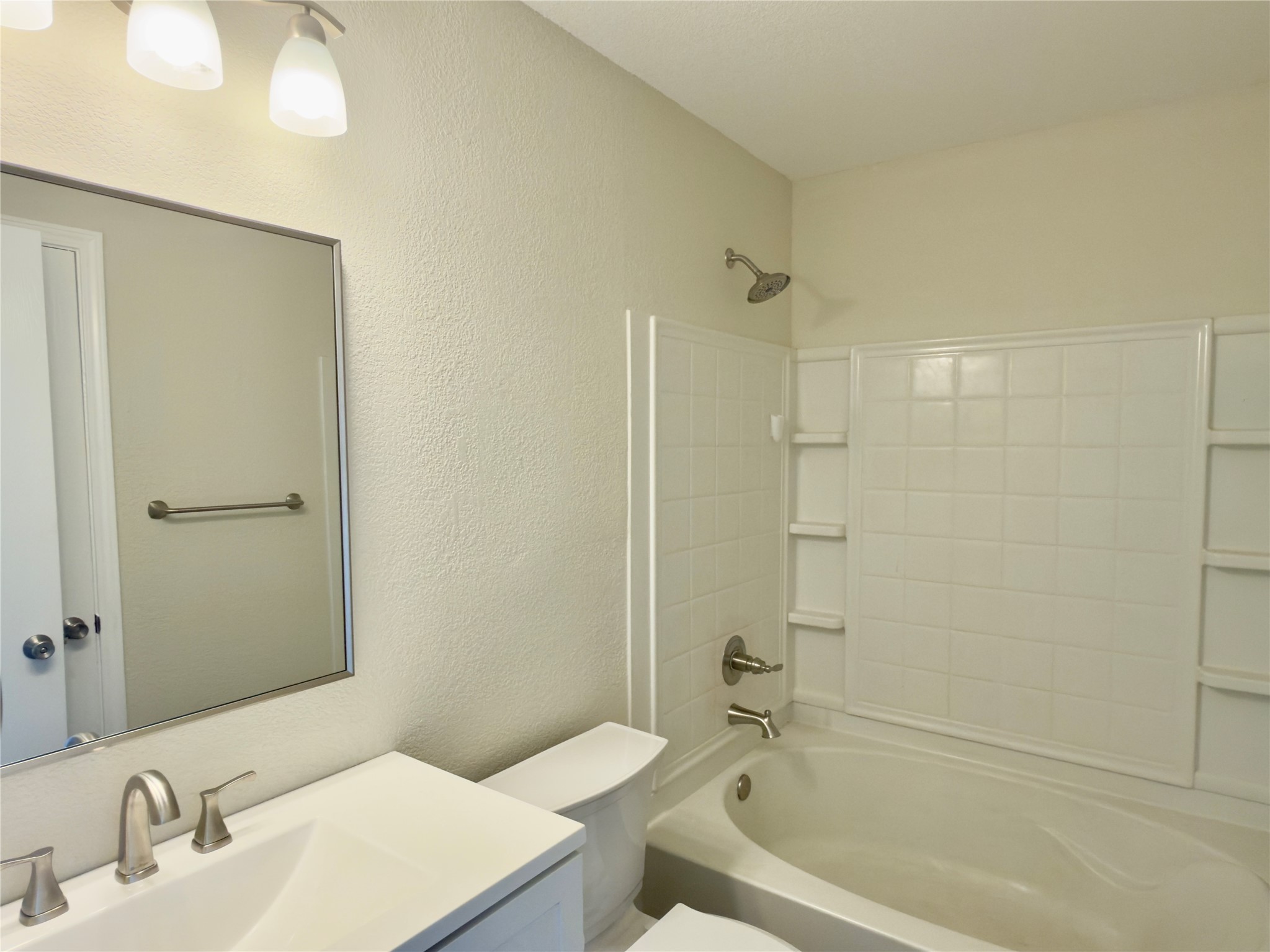 255 Myrtle Street Kyle, TX 78640 - Photo 23 of 31 Bathroom featuring a white vanity with integrated sink, brushed nickel faucet, and overhead bar lighting