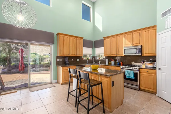 a kitchen with stainless steel appliances granite countertop a stove a sink dishwasher and a refrigerator