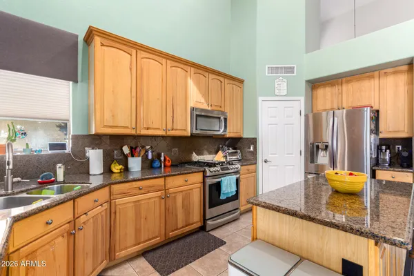 a kitchen with stainless steel appliances granite countertop a refrigerator sink and stove