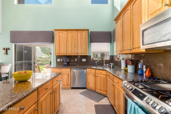 a kitchen with stainless steel appliances a sink a stove and large window