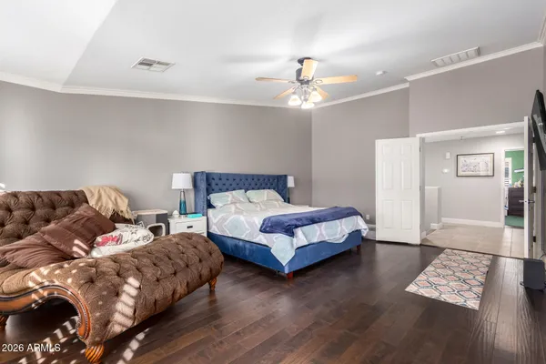 a bedroom with a bed and wooden floor