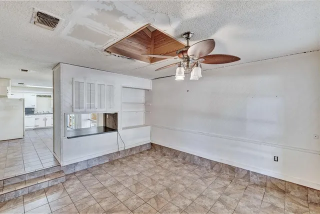 a view of a livingroom with wooden floor and a ceiling fan