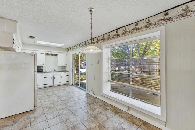 a large white kitchen with white cabinets and a wooden floor