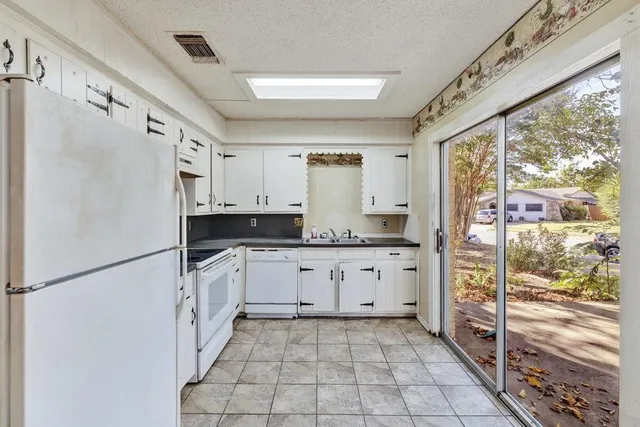 a kitchen with granite countertop cabinets and refrigerator