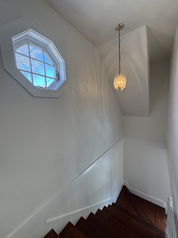 16 Cottage Street, Unit 2 Lynn, MA 01905 - Photo 18 of 25 an empty room with a wooden floor and chandelier
