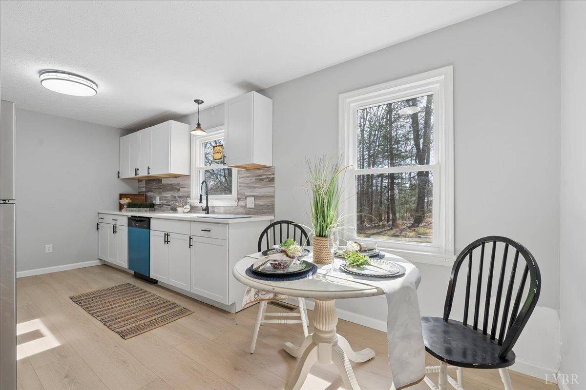 146 Watts Mill Road Pamplin, VA 23958 - Photo 13 of 37 a kitchen with a dining table chairs and white cabinets